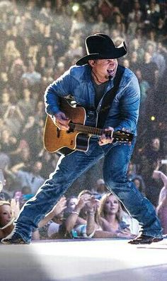 a man with a guitar in front of an audience