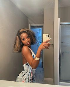 a woman is taking a selfie in the mirror with her cell phone while wearing a dress