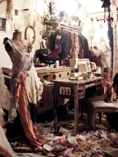 a messy room with clothes on the floor and an old sewing machine in the corner