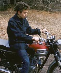 a man riding on the back of a red motorcycle