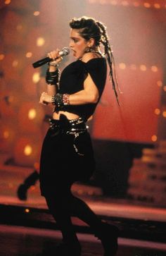 a woman with dreadlocks on stage singing into a microphone