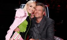 a man and woman sitting next to each other in front of a car at an event