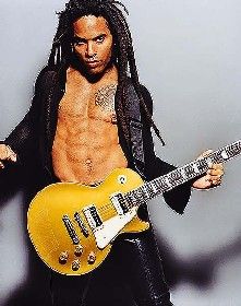 a shirtless man with dreadlocks holding an electric guitar and posing for the camera