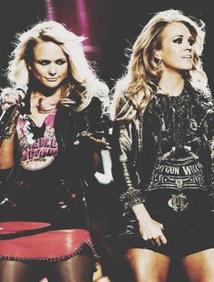 two beautiful young women standing next to each other in front of a microphone on stage