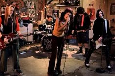 a group of people that are standing in front of some microphones and guitares