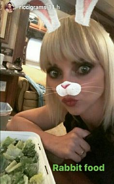 a woman with bunny ears on her head and some broccoli in front of her face