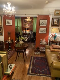 a living room filled with lots of furniture and paintings on the wall above it's windows