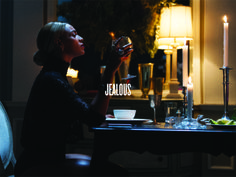 a woman sitting at a table with a wine glass in her hand and the words jellos on it