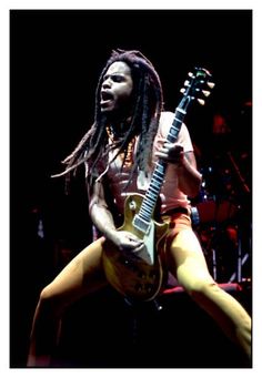 a man with dreadlocks playing an electric guitar