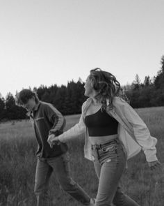 black and white photograph of two people walking in a field