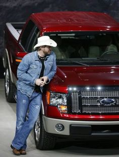 a man standing next to a red truck