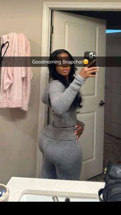 a woman is taking a selfie in the mirror with her cell phone while wearing grey