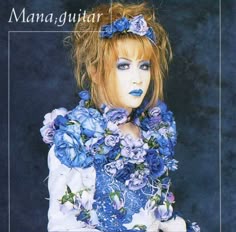a woman with blue makeup and flowers in her hair is posing for the cover of man, guitar magazine
