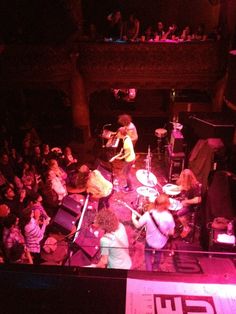 a group of people that are on stage with musical instruments in front of an audience