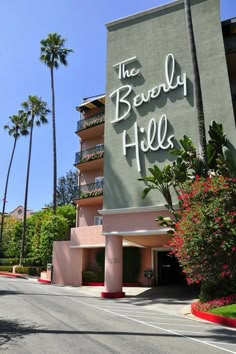the beverly hills hotel sign in front of palm trees