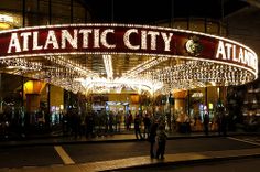 the entrance to atlantic city at night with people standing in front and onlookers