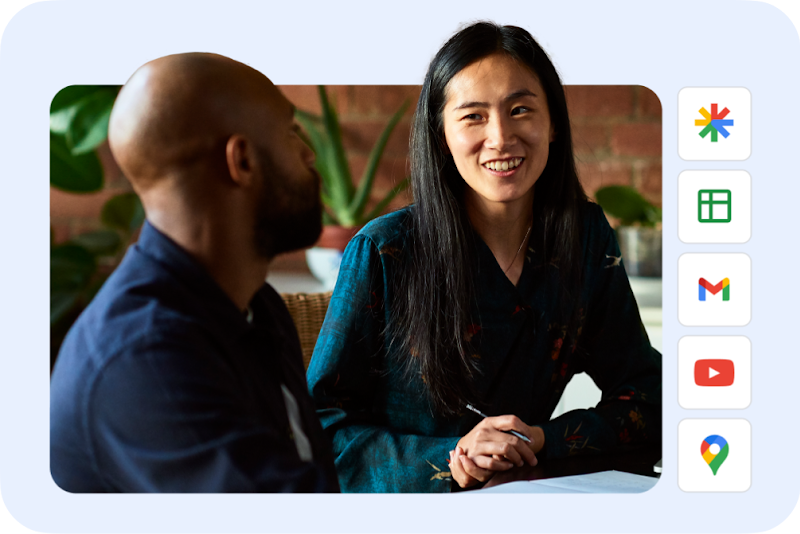 Two colleagues chatting at a table with icons of the properties Performance Max reaches.