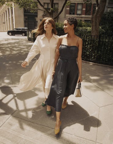 Two fashionable women in dresses walking city streets in Rothy’s shoes.